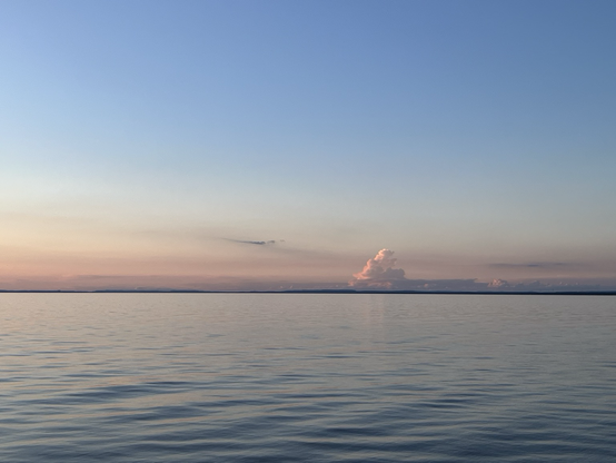 Calm sea, sunset colors, a funny triangular cloud shape protruding from the horizon