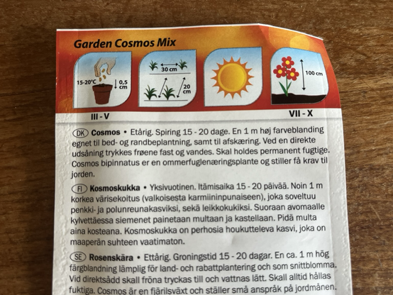 Bagsiden af en frøpose hvorpå der står: “Cosmos. Et-årig. Spiring 15-20 dage. En 1 m høj farveblanding egnet til bed- og randbeplantning, samt til afskæring. Ved en direkte udsåning trykkes frøene fast og vandes. Skal holdes permanent fugtige. Cosmos bipinnatus er en ommerfuglenæringsplante og stiller få krav til jorden.”