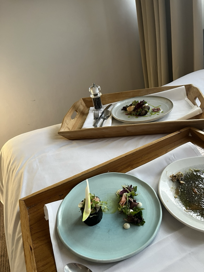 Hotelseng med to store bakker med i alt tre tallerkener. Den ene er tømt, den anden indeholder en slags spring roll (med porre?) og den sidste lammeköfte med lidt salat, tzatziki og brød. Alt er smukt anrettet på tallerkenerne som står ovenpå hvide stofservietter