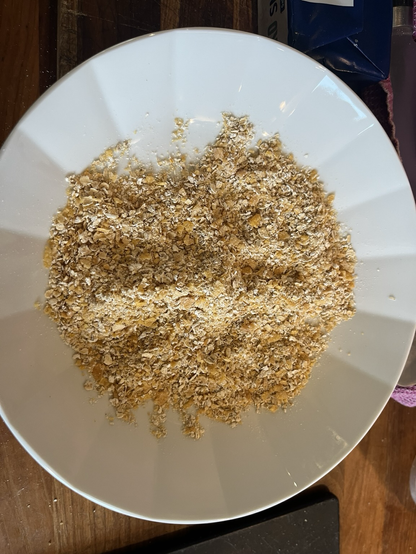 Hvid, dyb tallerken med en blanding af havregryn og cornflakes blendet til en slags rasp