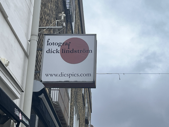 Skilt der reklamerer for “fotograf dick lindström”. Nederst på skiltet: “www.dicspics.com”