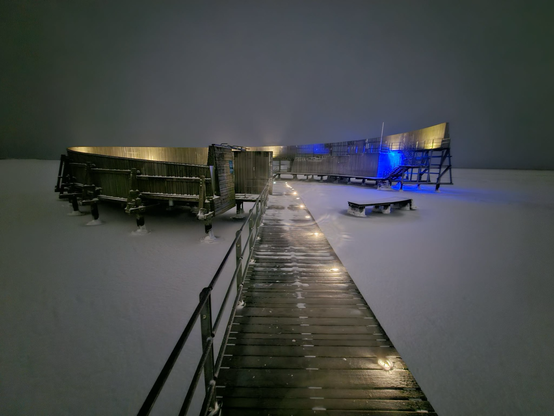 Sneglen i Øresund (badeanstalt ved Amager Strand) i gråligt aftenmørke, blå og hvid belysning og sne ud over det letfrosne hav