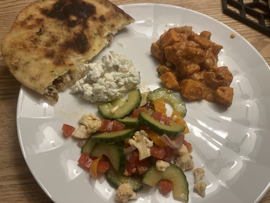 Hvid tallerken med indisk mad på som beskrevet ovenfor