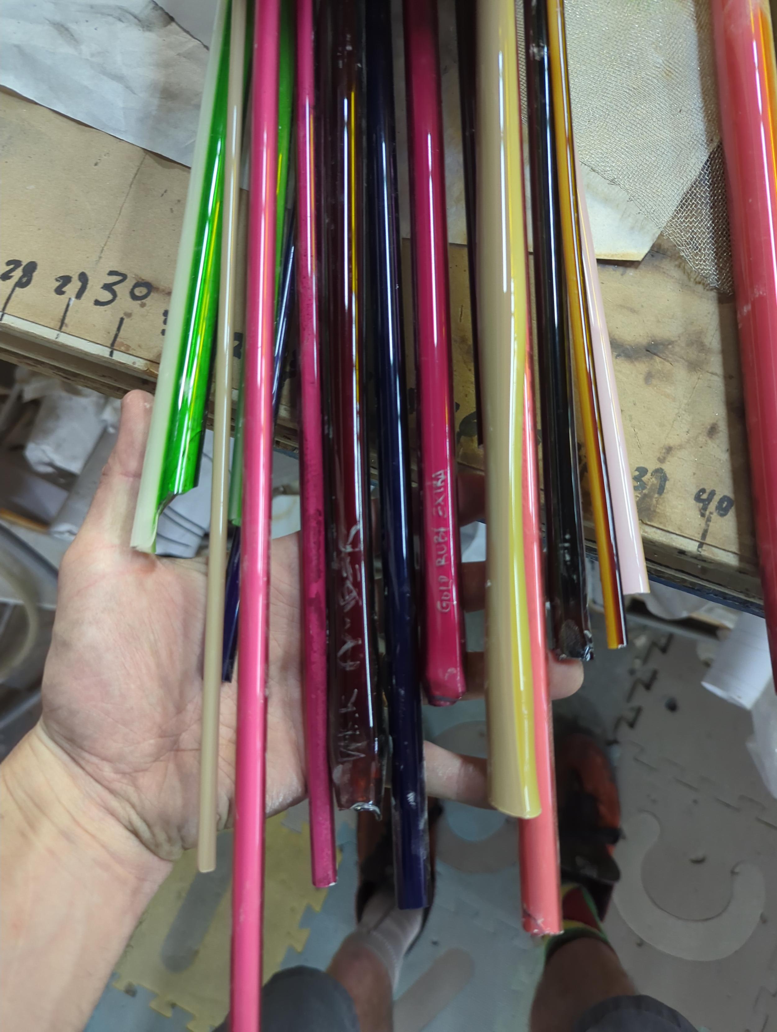 Holding a bunch of colorful glass tubes for neon. You cannot buy those colors