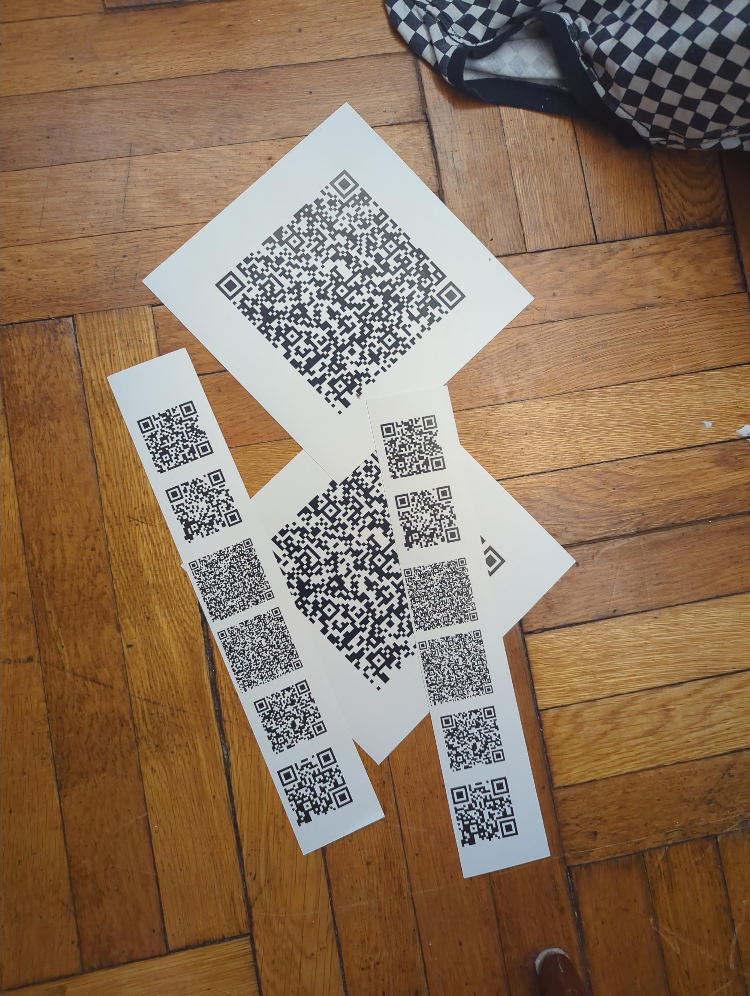 A bunch of QR codes as vinyl stickers on a wood floor