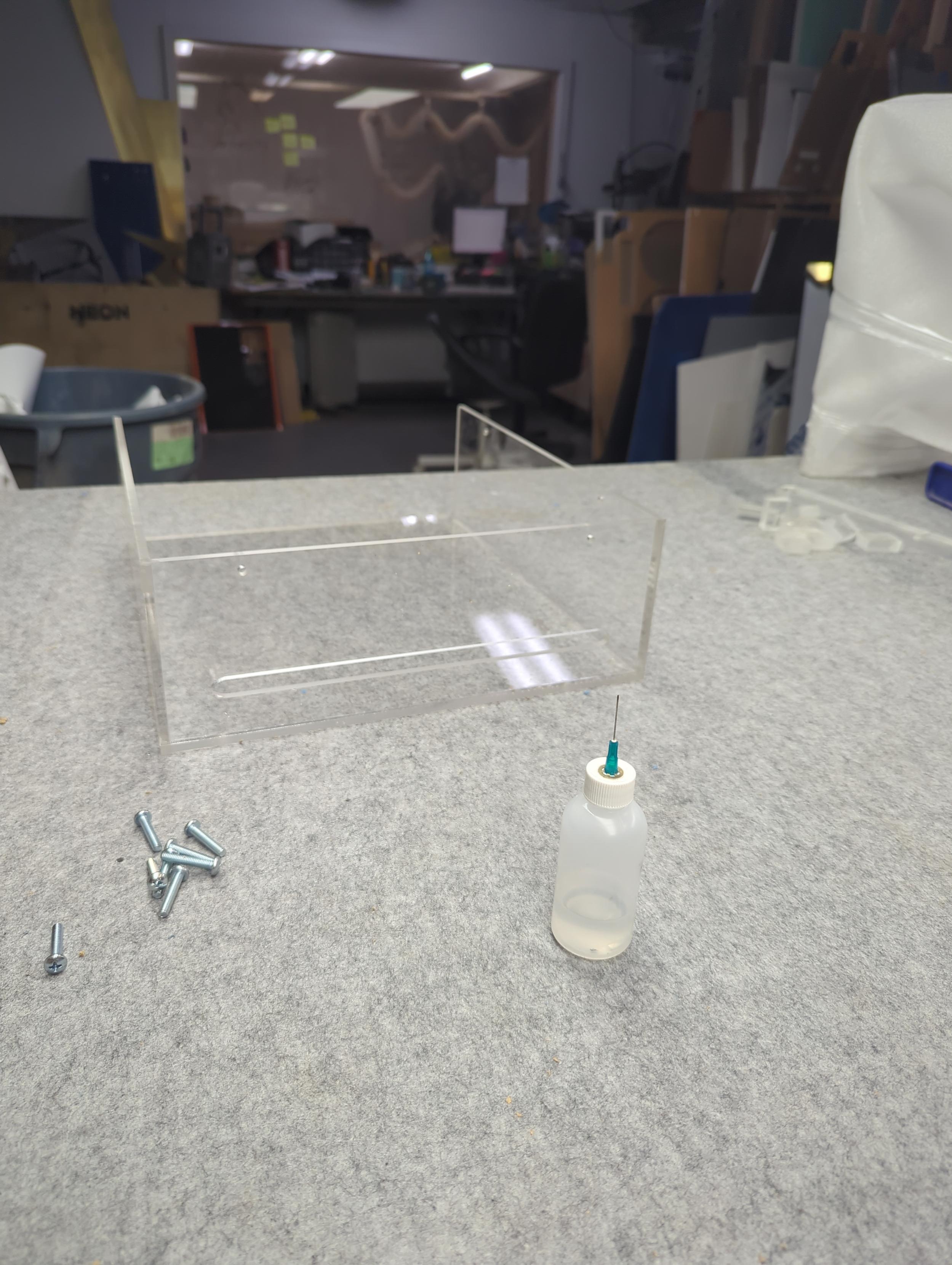 Hypo bottle, new acrylic box and screws on felt table