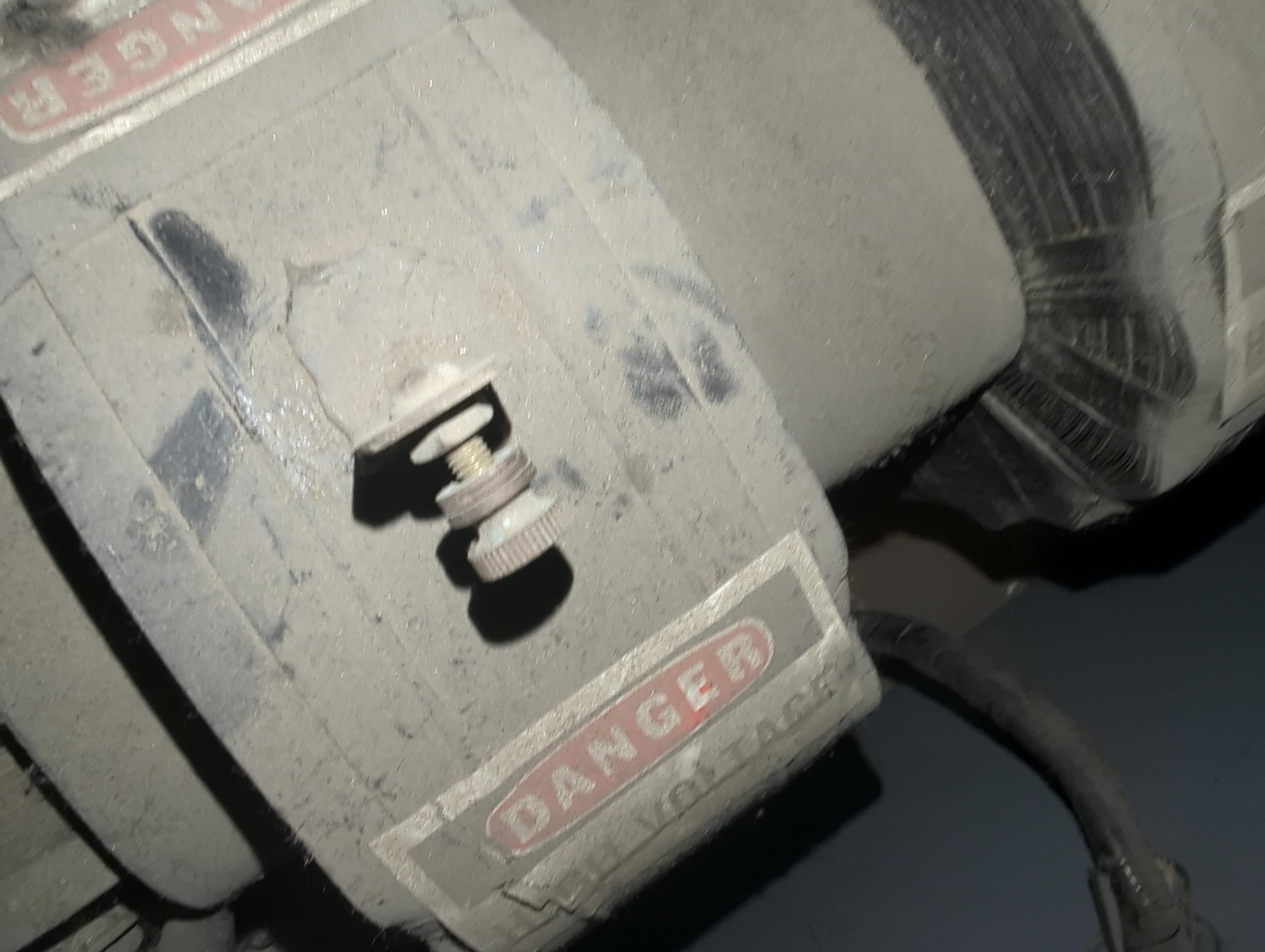 Giant high voltage coil transformer with screw in bushing termination missing a high voltage wire leading up to it- it needs a wire loop screwed in tightly.