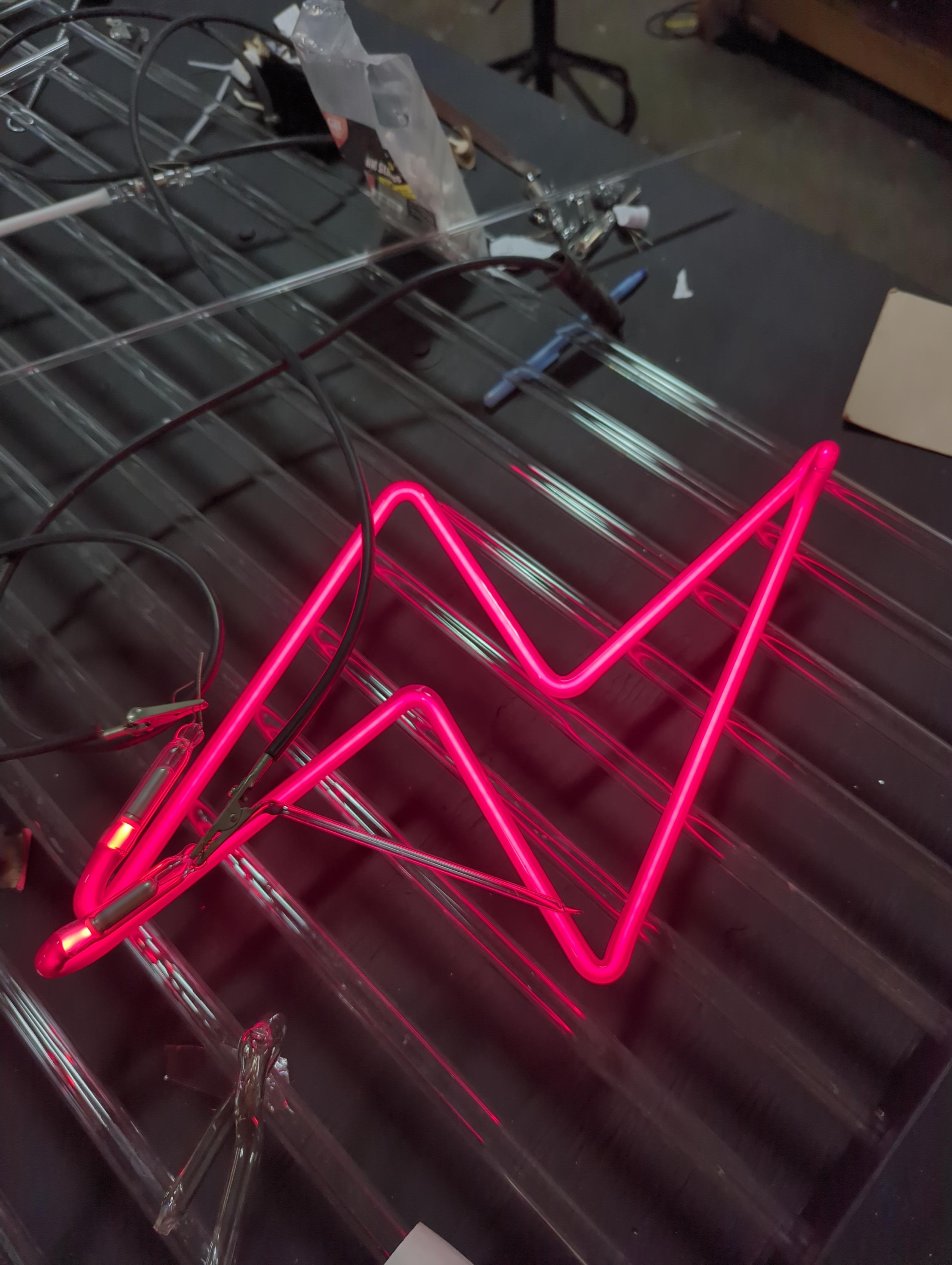 Intense red neon yet transparent tube for a ruby jewel tone light. This tube still has its tubulation on it- uncoated ruby glass is notorious for acting up after bombarding. I bombarded it several times very hot and it hasn't (yet) have a problem.
