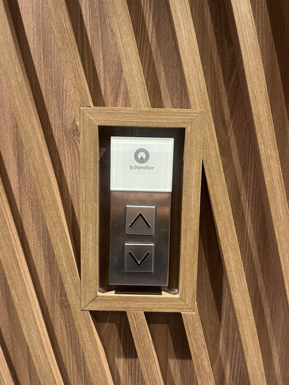 Knap til elevator med elevatorfirmaets navn: Schindler 