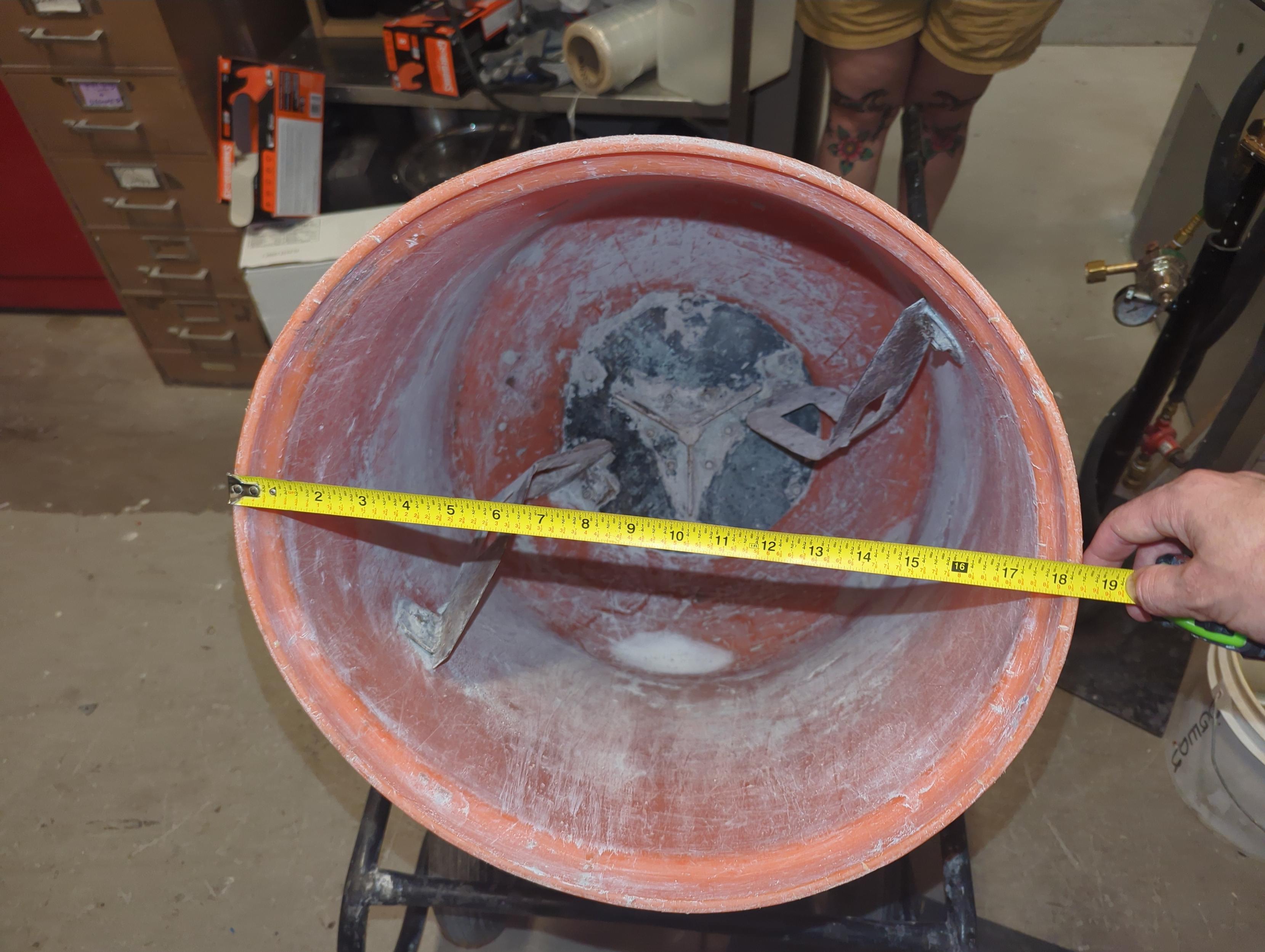 Dirty cement mixer with tape measure for getting size of lid